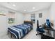 Cozy bedroom with natural light, featuring wood-look floors, a blue striped bed, and a dedicated desk space at 1626 Gar St, St Cloud, FL 34771