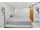 Bedroom featuring an upholstered headboard bed, white walls, and sliding barn door to bathroom at 1626 Gar St, St Cloud, FL 34771