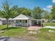 Charming cottage-style house with a welcoming front porch, covered parking, and a well-manicured lawn at 1626 Gar St, St Cloud, FL 34771
