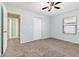 Spacious bedroom with soft blue walls, carpeted floors, a ceiling fan, closet and an open doorway at 1712 Melvin Ave, Orlando, FL 32806