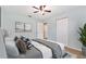 Serene bedroom with soft blue walls, ceiling fan, neutral accents, and a view leading to the hallway at 1712 Melvin Ave, Orlando, FL 32806