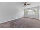 This is a shot of a carpeted bedroom featuring a ceiling fan and a bright window at 1712 Melvin Ave, Orlando, FL 32806