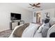 Modern bedroom features TV, ceiling fan, and view to the kitchen and office at 1712 Melvin Ave, Orlando, FL 32806