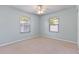 Carpeted bedroom featuring light blue walls, ceiling fan, and natural light from the dual windows at 1712 Melvin Ave, Orlando, FL 32806