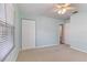 Carpeted bedroom boasting soft blue walls, ceiling fan, a double door closet and natural light at 1712 Melvin Ave, Orlando, FL 32806