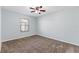 Spacious bedroom with blue walls, carpeted floors, a ceiling fan, and a large window at 1712 Melvin Ave, Orlando, FL 32806