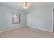 Bright carpeted bedroom features soft blue walls, ceiling fan, and natural light from the window at 1712 Melvin Ave, Orlando, FL 32806
