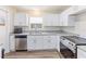 Bright kitchen featuring stainless steel appliances, white cabinets, granite countertops, and modern flooring at 1712 Melvin Ave, Orlando, FL 32806