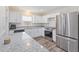 Modern kitchen with stainless steel appliances, granite countertops, and bright white cabinetry at 1712 Melvin Ave, Orlando, FL 32806