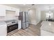 Bright kitchen boasts stainless steel appliances, granite countertops, and new flooring at 1712 Melvin Ave, Orlando, FL 32806