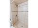 Tiled shower featuring mosaic accents, neutral tiling and stone floor in bright bathroom at 1712 Melvin Ave, Orlando, FL 32806