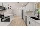 Eat-in kitchen with modern appliances, white cabinets, and an adjacent living space at 1842 Puritan Ave, Winter Park, FL 32792