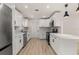 Modern kitchen with stainless steel appliances, white cabinets, and stone countertops at 1842 Puritan Ave, Winter Park, FL 32792