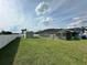 Large, green backyard featuring a screened-in pool area and storage shed near a white fence at 2410 Sweetwater Blvd, St Cloud, FL 34772