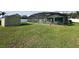 Screened-in pool with patio furniture, surrounded by a well-maintained green lawn and storage shed at 2410 Sweetwater Blvd, St Cloud, FL 34772