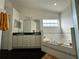Relaxing bathroom featuring dual vanity sinks and a sunken jacuzzi bathtub at 2410 Sweetwater Blvd, St Cloud, FL 34772