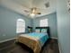 This bedroom features a beach themed comforter set and decor, with dark wood floors at 2410 Sweetwater Blvd, St Cloud, FL 34772