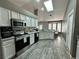 Kitchen featuring a skylight, stainless steel appliances, white cabinets, and eat-in table at 2410 Sweetwater Blvd, St Cloud, FL 34772