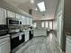 Bright kitchen featuring a skylight, stainless steel appliances, and white cabinets at 2410 Sweetwater Blvd, St Cloud, FL 34772