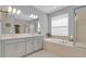 Well-lit bathroom with dual sinks, separate tub, and shower at 2679 Ridgetop Ln, Clermont, FL 34711