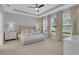 Spacious bedroom with a tray ceiling, neutral decor, and large windows for natural light at 2679 Ridgetop Ln, Clermont, FL 34711
