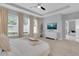 Comfortable bedroom showcasing tray ceilings, large windows, and a flatscreen TV at 2679 Ridgetop Ln, Clermont, FL 34711