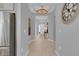 Hallway featuring modern lighting, light wood floors, and neutral paint, leading to the front door at 2679 Ridgetop Ln, Clermont, FL 34711