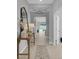 Bright hallway with wood floors, decorative mirror and lighting, leading to a view of the backyard at 2679 Ridgetop Ln, Clermont, FL 34711