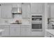 Well-equipped kitchen showcasing stainless steel appliances, light gray cabinetry, and a stylish tile backsplash at 2679 Ridgetop Ln, Clermont, FL 34711