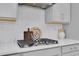 Close-up highlighting the gas cooktop, white countertops, and decorative elements of this well-designed kitchen at 2679 Ridgetop Ln, Clermont, FL 34711