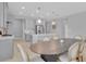 A view of the kitchen and dining area with modern appliances, an island, and stylish light fixtures at 2679 Ridgetop Ln, Clermont, FL 34711