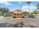 Community clubhouse with stone accents, a terracotta roof, and lush landscaping at 2826 Club Cortile Cir # B, Kissimmee, FL 34746