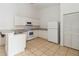 Kitchen featuring tile flooring, white cabinets and appliances, and breakfast bar at 2826 Club Cortile Cir # B, Kissimmee, FL 34746