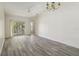 Spacious living room with gray wood-look flooring and a sliding glass door to a balcony at 2826 Club Cortile Cir # B, Kissimmee, FL 34746