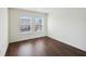 Sunlit bedroom features dark wood floors and two windows at 2828 Club Cortile Cir # B, Kissimmee, FL 34746