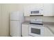 Well-equipped kitchen featuring white appliances, cabinetry, and countertops at 2828 Club Cortile Cir # B, Kissimmee, FL 34746
