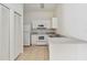 Kitchen featuring white cabinets and appliances, with tile flooring and ample counter space at 2828 Club Cortile Cir # B, Kissimmee, FL 34746