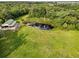 Aerial view of a pond with a dock surrounded by lush green lawns and mature trees at 2851 Wagon Ct, St Cloud, FL 34772