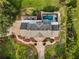 Beautiful aerial view showcasing an estate's layout with a screened-in pool, patio, and meticulously designed landscaping at 2851 Wagon Ct, St Cloud, FL 34772