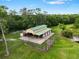 Aerial view of a barn with a green metal roof, fenced yard, and access to a pond at 2851 Wagon Ct, St Cloud, FL 34772