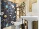 Bathroom features a toilet, pedestal sink, decorative shelf, and a fun shower curtain at 2851 Wagon Ct, St Cloud, FL 34772