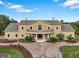 Stunning two-story tan home featuring a brick drive, covered front porch and a 2nd story veranda at 2851 Wagon Ct, St Cloud, FL 34772