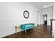 Stylish hallway with a teal bench, gold side tables, and a round mirror on the white wall at 2851 Wagon Ct, St Cloud, FL 34772