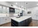 Well-lit kitchen with a large island with white countertop, dark cabinets, and modern pendant lighting at 2851 Wagon Ct, St Cloud, FL 34772