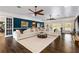 Open concept living room area with hardwood floors, white sofas, and large windows, a perfect space for entertaining at 2851 Wagon Ct, St Cloud, FL 34772