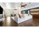 Bright and airy living room featuring wood floors, white couches, ceiling fans and blue accent wall at 2851 Wagon Ct, St Cloud, FL 34772
