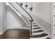 Elegant staircase with dark wood steps, white risers and railing, and stylish wall decorations at 2851 Wagon Ct, St Cloud, FL 34772