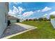 Spacious backyard with a stone patio, lush green lawn, and privacy fence offers ample space for outdoor activities at 3053 Royal Tern Dr, Winter Haven, FL 33881