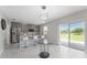 A modern kitchen with stainless steel appliances, an island with seating, and sliding glass doors to the patio at 3053 Royal Tern Dr, Winter Haven, FL 33881