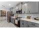 Modern kitchen with stainless steel appliances, light grey cabinets, tile backsplash, and ample storage at 3053 Royal Tern Dr, Winter Haven, FL 33881
